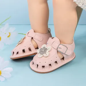 Close-up of pink baby girl sandals featuring 3D flower petals and breathable hollow toe design