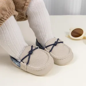 Detailansicht der cremefarbenen Leder-Babyschuhe mit Lochmuster und Denim-Fersenpatch
