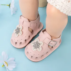 Macro view of light pink baby sandals featuring 3D leather flower and velcro closure