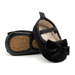 Détail de chaussures bébé en velours avec grand nœud et semelle antidérapante