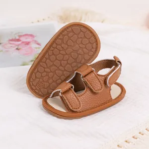 Detail of brown PU leather baby sandals showing dual hook-and-loop straps and anti-slip sole