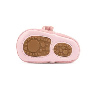 Gros plan sur des chaussures bébé roses avec semelles souples antidérapantes