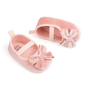 Détail de chaussures bébé en velours rose avec nœuds élégants et bride élastique