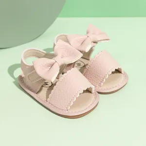 Cute light pink baby sandals with bow and scalloped edges for infant walking
