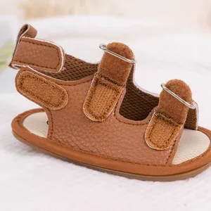 Detail of infant brown PU leather sandals with triple hook-and-loop straps and metal D-rings