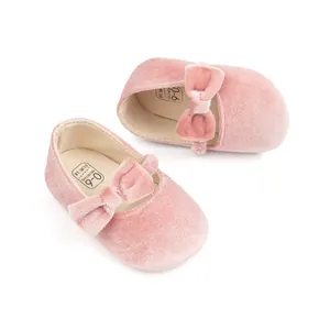 Gros plan sur les chaussures bébé Mary Jane en velours rose avec de grands nœuds doux
