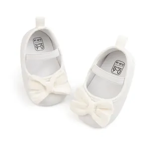 Détail de chaussures bébé à nœud en velours blanc montrant la taille pour 0-6 mois