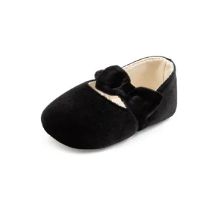 Détail de chaussures de princesse bébé en velours noir avec nœud doux et semelle souple