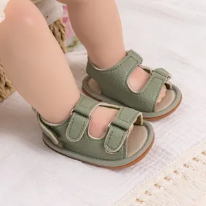 Close-up of sage green baby sandals with double velcro straps and soft rubber soles