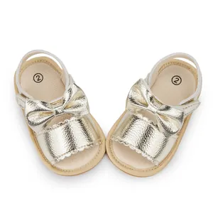Detail of golden baby sandals featuring a decorative bow and soft non-slip PU leather sole