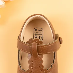 Detail of brown baby T-strap shoes with scalloped edges and 0-6 months size marking