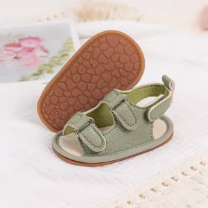 Detail of baby summer sandals featuring light green leather and non-slip textured soles