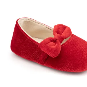 Détail de chaussures bébé fille en velours rouge avec nœud et doublure douce