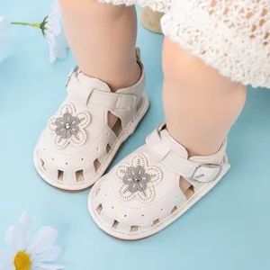 Detail of baby girl sandal featuring a leather flower charm and adjustable velcro strap