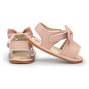 Close-up of pink PU baby sandals featuring elegant bow accents and velcro closure