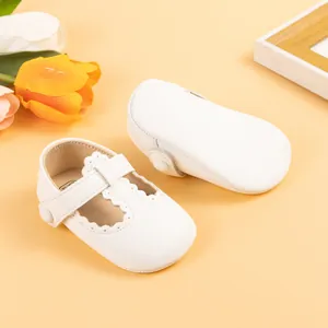 Close-up of white baby Mary Jane shoes with wavy edges and soft soles for walking