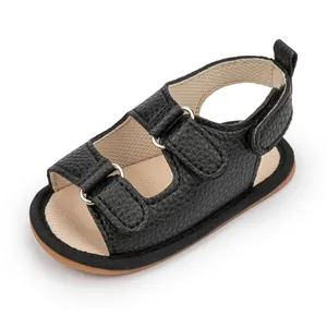 Detail of baby summer sandals with black pebble grain PU leather and velcro straps
