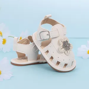 Detail of white baby sandals with 3D floral accents and adjustable strap closures