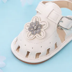 Detailed view of white baby sandals featuring intricate 3D leather flower and petal accents