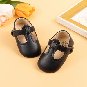 Detail view of black Mary Jane baby shoes with scalloped edges and button closure