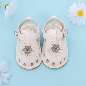 Detail of baby girl sandals featuring a soft cream leather flower and hollow out design