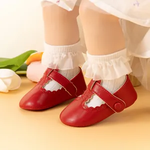 Detailed macro view of red baby Mary Jane shoes with wavy edges and lace socks