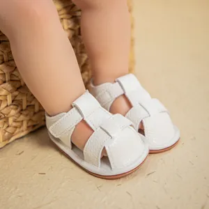Detail of white infant fisherman sandals featuring textured faux leather and velcro straps