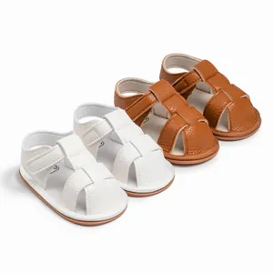 Detail of white and brown baby sandals with lychee grain leather and velcro straps