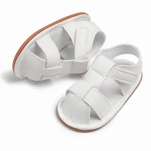 Detail of white PU leather baby sandals with soft brown soles and velcro closure