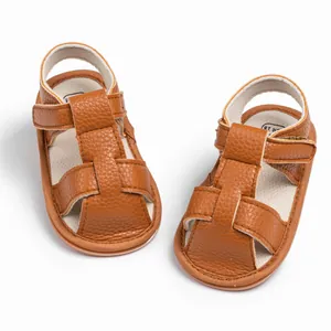 Detailed top view of brown leather baby sandals with soft soles and T-strap velcro closure