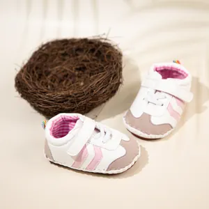 Detail of baby sneakers with pink stripes, velcro closure, and rainbow heel tab