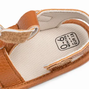 Close-up of soft inner lining and size markings on brown leather infant walking sandals