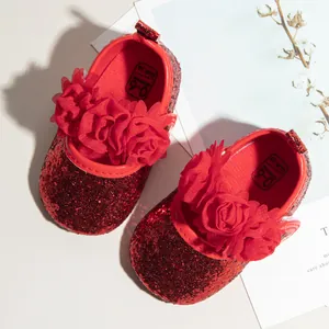 Close-up of red sequin baby shoes with 3D floral accents and soft cushioned soles