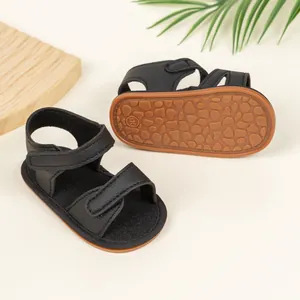 Macro view of non-slip rubber sole with pebble texture on black baby sandals