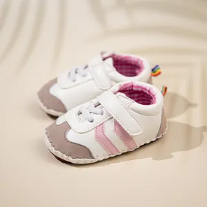 White and pink soft-soled baby walking shoes with velcro straps and rainbow heel tab