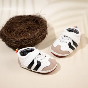 Detail of baby sneakers featuring soft PU sole, hook-and-loop strap, and rainbow heel pull tab