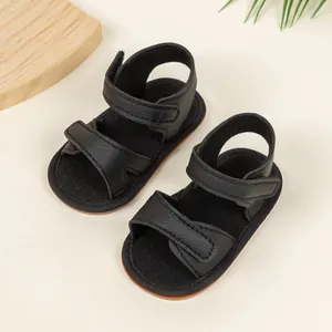 Detail of black faux leather baby sandals with anti-slip soles and double velcro straps