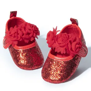 Detail of red sequin baby shoes with 3D fabric flowers and secure velcro strap