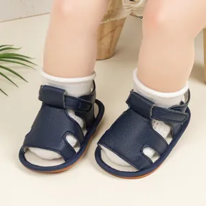Detail of navy blue baby sandals with velcro strap on infant wearing white socks