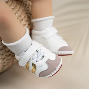 Detail view of baby walker shoes in white and gold with velcro closure and soft soles