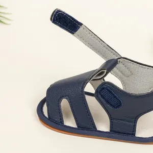 Detailed view of the navy blue leather baby sandal featuring velcro strap and fine stitching