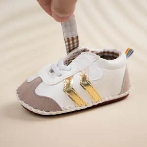 Detail of infant walking shoe with velcro strap open, faux suede trim and soft sole