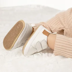 Detail view of white baby leather shoes featuring anti-slip soles and velcro straps