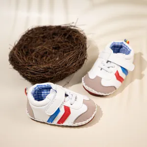 Detail view of white baby sneakers with blue gingham lining and decorative bird nest