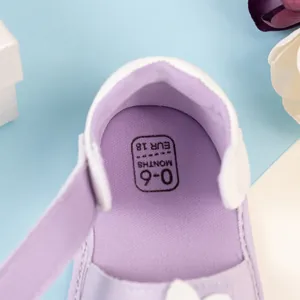 Primo piano di scarpe per neonati in tessuto viola con fodera interna e taglia