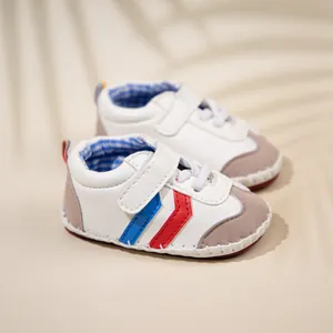 Detail of infant walking shoe with white PU upper, magic tape, and blue-red V stripes
