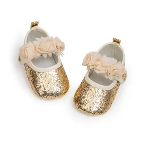 Detailed top view of gold sequin baby princess shoes with 3D floral accents and strap