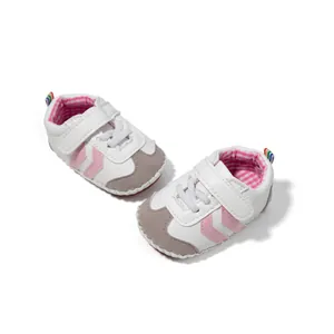 Close-up of soft-sole baby walking shoes with pink stripes and rainbow heel loops