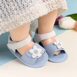 Dettaglio di sandali neonata con fiori 3D bianchi e velcro su morbida pelle PU azzurra