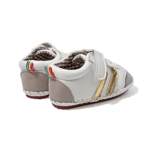 Detail view of baby walking shoes with gold stripes and rainbow heel pull tab